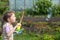 a five-year-old girl blows large soap bubbles in the garden