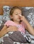 A five-year-old girl buries herself with drops in her eye while lying in bed. Self-treatment