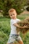 five-year-old red-haired boy collects hay to feed the cattle. Farmer\\\'s child helps collect hay