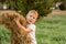 five-year-old red-haired boy collects hay to feed the cattle. Farmer\\\'s child helps collect hay