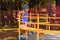 Five-year-old smiling Caucasian boy in a hat riding a big children`s carousel in a summer Park