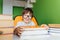 Five years old child reading a book at home. Boy studying at table on green background