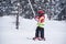 Five years old little skiing girl holding tight a handle of a sk