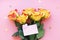five yellow-red roses on a pink background, golden plastic hearts and a pink card with a heart. space for text.
