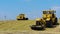 Five Yellow Tractors Tamp Silage in the Silo Trench