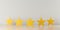 Five yellow wooden stars on table in row with selective focus on center star, five star review for best service or product quality