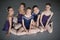 Five young ballerinas sitting on the floor