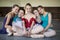 Five young ballerinas sitting on the floor