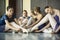 Five young dancers in the same dance costumes, resting sitting o