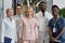 Five young and experienced doctors standing in front of camera in hospital