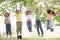 Five young friends jumping outdoors smiling