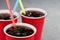 Fizzy drink with ice in red cups with colored straws