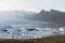 FJALLSARLON, ICELAND - AUGUST 2018: people walking on the shore of Vatnajokull glacier lagoon at sunset