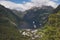 Fjord, green mountains and snow-covered tops. Geiranger, Norway