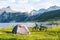 Fjord and mountain landscape in Norway with bike and tent on a grassland