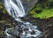 Fjordland, West Iceland - Waterfall tumbles into lush green valley