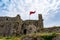 The flag of Albania flies atop the medieval wall of the Rozafa fortress in Shkodra. Red flag with a black double-headed eagle