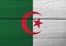 Flag of Algeria on wooden wall background. Grunge Algerian flag texture.