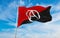 flag of Anarchist with A symbol at cloudy sky background on sunset, panoramic view. Anarchism symbol.. copy space for wide