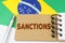 On the flag of Brazil lies a notebook with the inscription - Sanctions