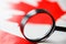 The flag of CANADA looks through a magnifying glass. Study of the history and culture and people of the country of Canada. The