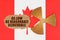 On the flag of Canada, the symbol of radioactivity and torn cardboard with the inscription As Low As Reasonably Achiev