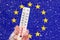 Flag of Europe Union and snowfall. Celsius and fahrenheit scale thermometer in hand. Ambient temperature minus 6