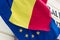 Flag of the European Union covered with the Romanian flag. Political relations and union concept. Close-up view.