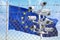 Flag of Europen Union EU behind barbed wire fence and cctv cameras. Concept of closing borders from refugees, discrimination and