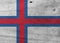 Flag of Faroe Islands on wooden plate background. Grunge Faroe Islands flag texture.