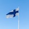 Flag of Finland waving over blue sky