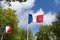 Flag of France against the sky and green trees, french flags waving in the wind