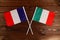 Flag of France and flag of Italy crossed with each other. The image illustrates the relationship between countries