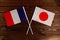 Flag of France and flag of Japan crossed with each other. The image illustrates the relationship between countries