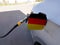 Flag of Germany on the car`s fuel tank filler flap. Petrol station. Fueling car at a gas station