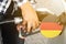 The flag of Germany on the lid of the gas tank with a filling gun inserted into it.