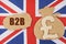 On the flag of Great Britain, a bag with a money symbol and a cardboard with the inscription - B2B