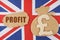 On the flag of Great Britain, a bag with a money symbol and a cardboard with the inscription - profit