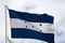 Flag of Honduras  waving against cloudy sky