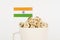 The flag of India sticks out of a cup with cubes on which letters are depicted