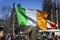 Flag of Ireland close-up in hands of man, on background of crowd people during the celebration of St. Patrick`s Day in