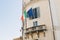 Flag of Italy with EU flag hanging on the balcony of a house. Flags in the facade of old building