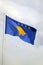 Flag of Kosovo on a blue sky with clouds background