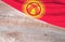 Flag Kyrgyzstan and space for text on a wooden background