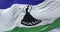 Flag of Lesotho waving at wind with blue sky in slow, loop