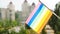 Flag of the LGBTQ set against blue sky and city street. Rainbow stripes on colorful LGBT flag. LGBTQIA flag waving. The holiday