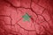 Flag of Marocco. Maroccan symbol. Flag on the background of dry cracked earth.