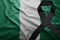Flag of nigeria with black mourning ribbon