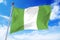 Flag of Nigeria developing against a blue sky