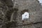 Flag of Poland seen through a window of a ruined castle in misty weather